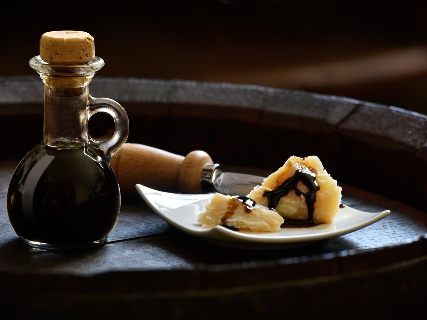 Aceto Balsamico e scaglie di Parmigiano Reggiano su una botte di rovere